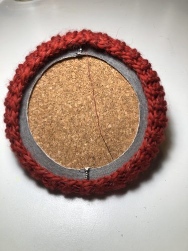 Der Korkuntersetzer steckt nun an der Oberkante der Loops und dehnt beide Loops.