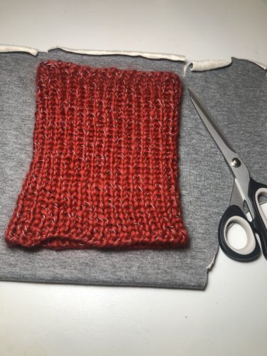Der Strickloop liegt auf dem Jersey Stoff als Schnittvorlage