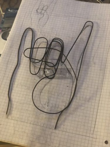 Die Metal Hand ist fertig und liegt auf der Vorlage. Man sieht dass der Daumen etwas größer geworden ist als in der selbstgezeichneten Vorlage