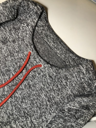 Detailaufnahme des fertig genähten Halsausschnitts mit breitem Tunnelzug. Die rostrote Kordel ist durch die Ösen gezogen.