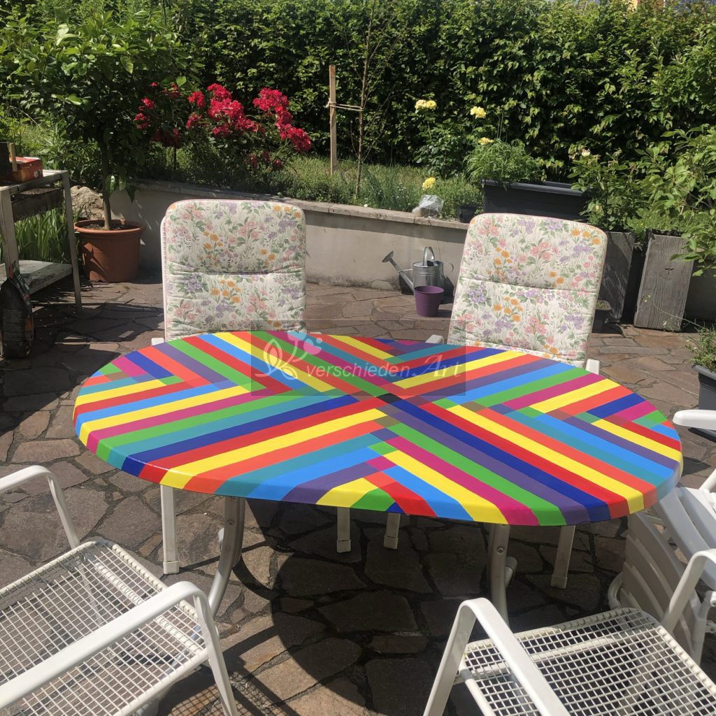bunt bemalter Gartentisch auf der Terrasse mit Gartenstühlen