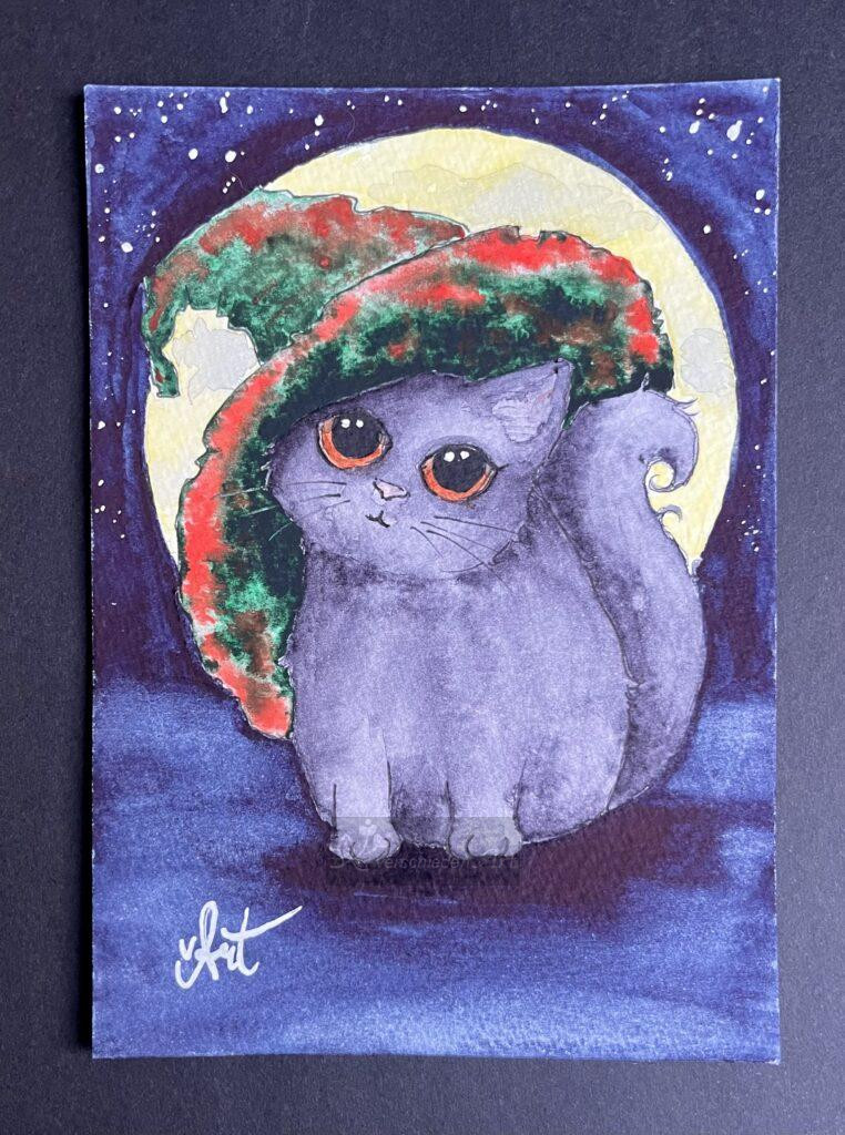 Zauberkätzchen bei Vollmond. Aquarellbild; graue Katze mit braunen großen Augen sitzt in der dunklen Nacht vor einem riesigen gelben Mond, der die Katze umhüllt. Sie hält den Kopf etwas schief weil sie einen großen grün-orangen Hexenhut trägt.